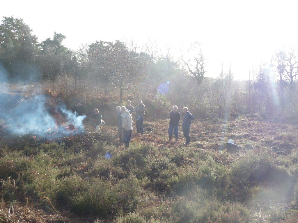 Volunteers around bonfire at end of task